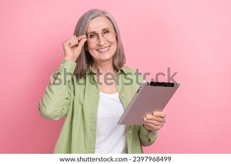 Photo clever retired woman touch spectacles browsing concentrated modern tablet good productivity device isolated on pink color background