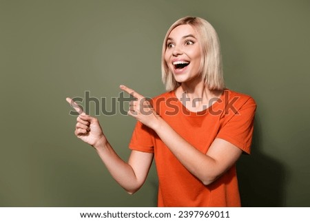 Photo portrait of lovely young lady point empty space excited wear trendy orange garment isolated on khaki color background