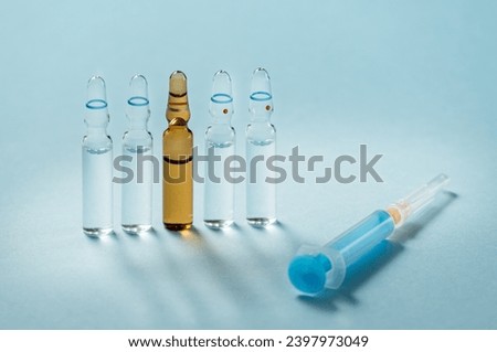 Syringe and needle with glass medical ampoule vials for injection. Medicine is dry white drug penicillin powder or liquid with of aqueous solution in ampulla Royalty-Free Stock Photo #2397973049