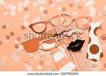 Photo booth props glasses, mustache, lips on a pink background flat lay. Birthday parties and weddings. New trending PANTONE 13-1023 Peach Fuzz colour of 2024 year