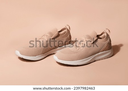 Pink pastel color sneakers on background. New trending PANTONE 13-1023 Peach Fuzz colour of 2024 year
