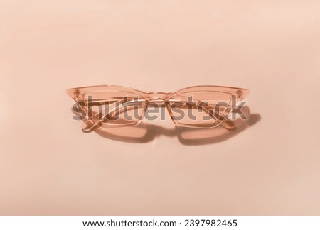 Summer sunglasses on a pink background. New trending PANTONE 13-1023 Peach Fuzz colour of 2024 year