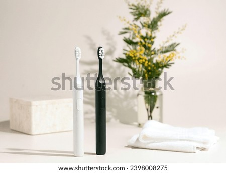 New modern ultrasonic toothbrushes. Dental care materials with green leaves on a white background. Oral hygiene, gum health, healthy teeth. Smart wireless ultrasonic toothbrush.  Modern health concept