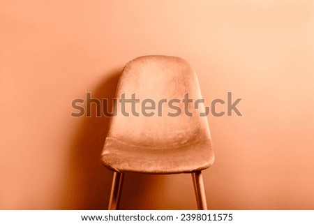 Modern Velour Chair Peach Fuzz, color of the year 2024 on wooden legs, grey background Royalty-Free Stock Photo #2398011575