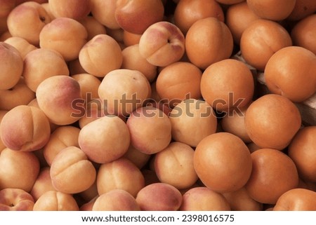 Fruits apricots, peaches, natural background, blur, selective focus. Color of the year 2024, peach fuzz color Royalty-Free Stock Photo #2398016575