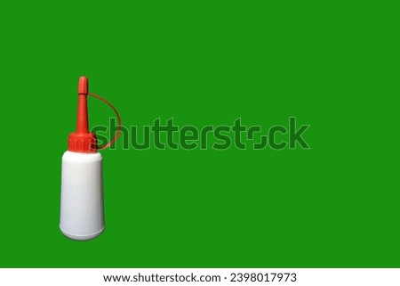 An unbranded plastic oil can with white body and red lid, set against a vibrant green background. 