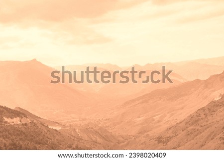 Beautiful sunny day in mountain valley and mountainous countryside landscape in summer toned in pantone color of year 2024 Peach Fuzz Royalty-Free Stock Photo #2398020409