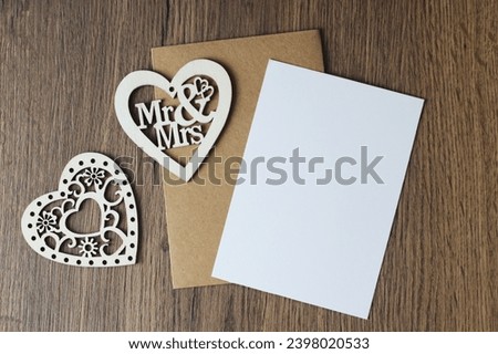 Wedding invitation and greeting card with copy space and envelope mock up, vertical flat composition with decoration and wood background postcard template.