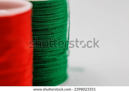 Up Close macro image of a red and green spool of thread with copy space spreading holiday cheer for the Christmas holiday 