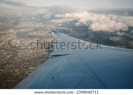 Beautiful clear deep blue sky over thick layer of clouds at stratosphere atmosphere viewed from airplane's window located above airplane's wing and jet.