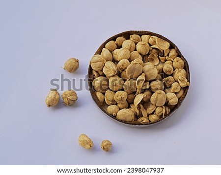 Top view shot of dried Java cardamom seeds (Amomum Compactum) in a container, isolated white background