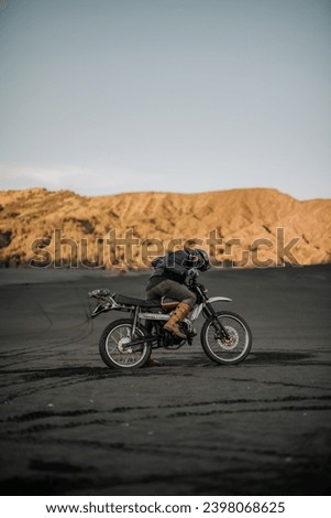 A lone biker in the morning while dirt biking on savannah of Mount Bromo