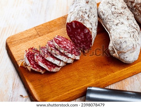 Traditional italian dry cured sausage salamini sliced on wooden surface Royalty-Free Stock Photo #2398078479