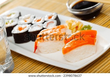 Assorted sushi set from makizushi, hosomaki and nigirizushi served on white plate with wasabi and pickled ginger. Popular Japanese dish.. Royalty-Free Stock Photo #2398078637