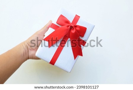 a bird's eye view of photo man asian hands holding of craft paper gift box with red ribbon bow isolated on a white backdrop. new year's day, christmas, valentine's day concept