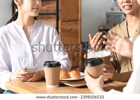 Young Asian women having a conversation at a restaurant Royalty-Free Stock Photo #2398106533