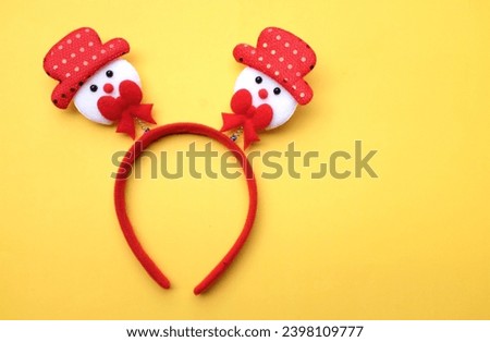 cute Christmas headbands with snowman's isolate on a yellow backdrop. concept of joyful Christmas party,New year is coming soon, festive season decoration with Christmas elements