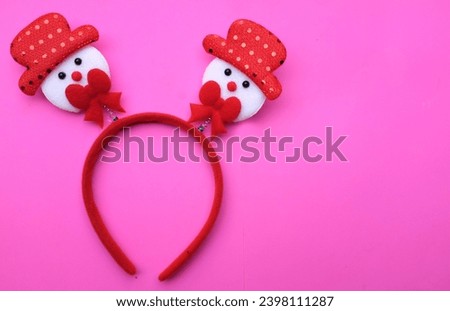 cute Christmas headbands with snowman's isolate on a pink backdrop. concept of joyful Christmas party,New year is coming soon, festive season decoration with Christmas elements