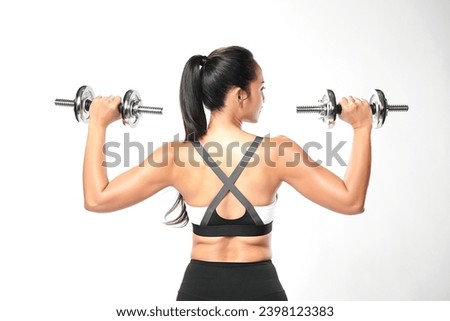 an asian woman is working out with dumbbells wearing the sport exercise suit with white background, Royalty-Free Stock Photo #2398123383