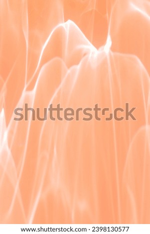 Wavy lines of light as Abstract background peach colored, natural flare from lights, trend color year 2024 peach fuzz monochrome photo with optical effect, blur texture as holiday backdrop, wallpaper