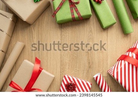 Christmas present boxes and rolls of wrapping paper. Festive presents composition with copy space. Variety of wrapped xmas gifts. Winter holiday season gift guide. Seasonal flat lay, above top view.