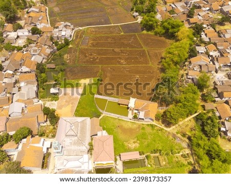 Industrial Photography. Aerial Landscapes. Top view of agricultural field in the middle of the urban landscape, located on the edge of the city of Bandung - Indonesia. Aerial Shot from a flying drone.
