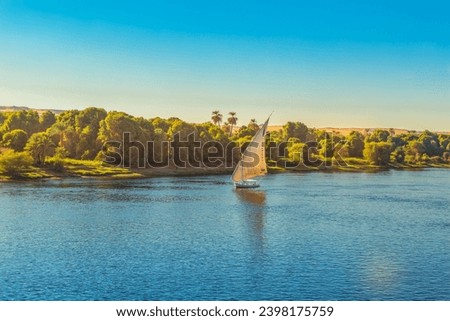 Traditional felucca boat on the Nile River. Magnificent views of the Nile at sunset. Aswan, Egypt - October 19, 2023. Royalty-Free Stock Photo #2398175759