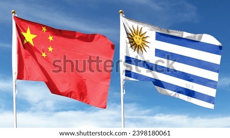 Chinese flag and Uruguay flag on cloudy sky. fly in the sky Royalty-Free Stock Photo #2398180061