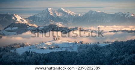 Winter fairytale in Slovenia - a foggy snowy sunrise in a countryside landscape with the church of Sveti Tomaz