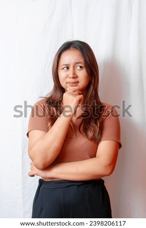 Confused young asian woman has a thinking attitude on a white background
