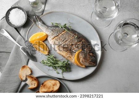 Seafood. Delicious baked fish served on grey textured table, flat lay