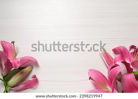 Beautiful pink lily flowers on white wooden table, flat lay. Space for text Royalty-Free Stock Photo #2398219947