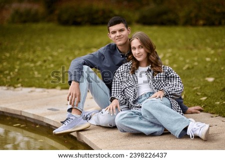 Young couple kissing and rejoices at the lake. lovely young couple kissing outdoors in autumn. Loving couple walking in nature. Autumn mood. Happy man and woman hugging and kissing in autumn. Love Royalty-Free Stock Photo #2398226437