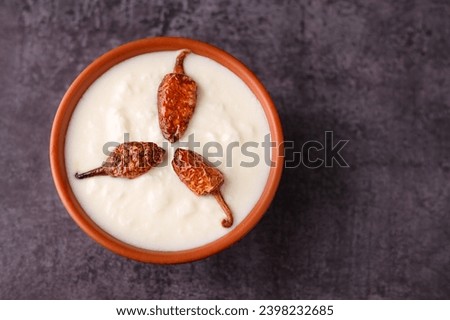 Bowl of homemade sour cream curd yogurt Dahi fresh herbs curry leaf Kerala India. Dairy product obtained coagulating milk process curdling. probiotic food tasty curd rice curry spices Royalty-Free Stock Photo #2398232685