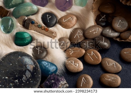 handmade stone runes on white fur Royalty-Free Stock Photo #2398234173
