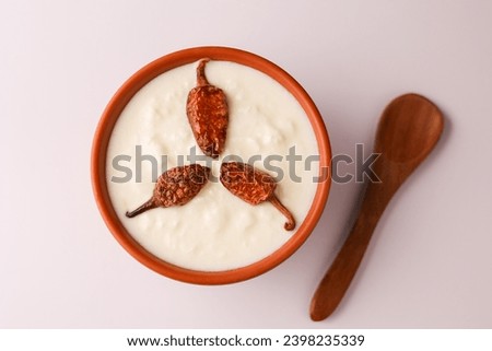 Bowl of homemade sour cream curd yogurt Dahi fresh herbs curry leaf Kerala India. Dairy product obtained coagulating milk process curdling. probiotic food tasty curd rice curry spices Royalty-Free Stock Photo #2398235339
