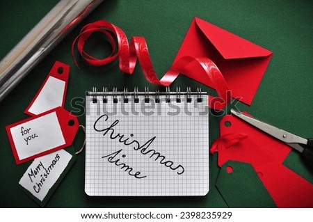 christmas time write n notepad between handmade christmas cards, wrapping paper, ribbon and letter 