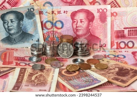 Close-up view of Yuan coins in stacks and Yuan paper money. Chinese economy, finance and international relations. Currency background. World trade, inflation, investment, business and lending