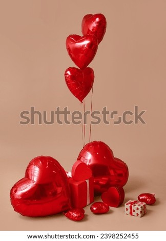 Heart shaped air balloons and gift boxes on brown background Royalty-Free Stock Photo #2398252455