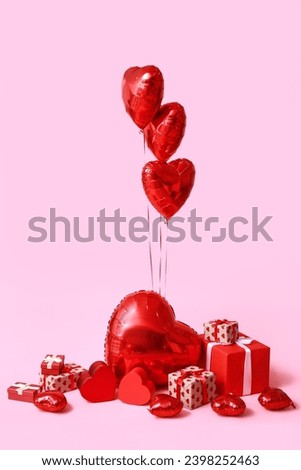 Heart shaped air balloons and gift boxes on pink background Royalty-Free Stock Photo #2398252463