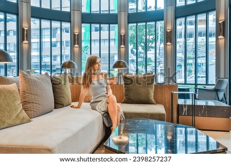 Woman relaxing in modern lounge area with elegant interior design. Interior and lifestyle.