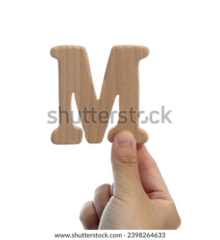 Hand holding wooden letter M