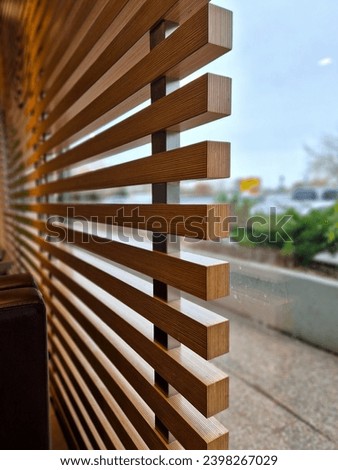 a window grill made of clay slats in a restaurant or office shields from direct sunlight and protects people inside. checkered plywood side view of blinds