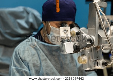 A veterinary surgeon performs surgery on a pet's eyes in a veterinary clinic. An ophthalmologist performs microsurgery on a pet's eye under a special microscope.