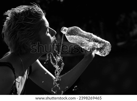 Cute blond girl playing with water in the summer in Denmark, shot against light