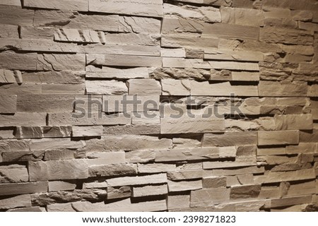 Sandstone bricks on an interior wall with shadows and deep rustic texture photo.