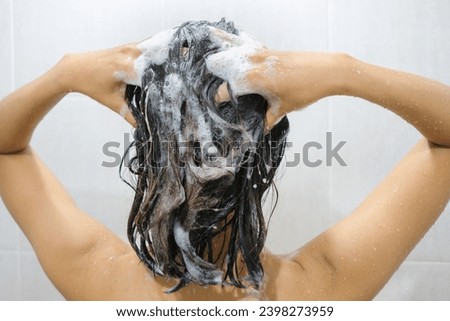 Beautiful woman's hand She was washing her hair and nourishing her scalp. Shampoo and conditioner Royalty-Free Stock Photo #2398273959