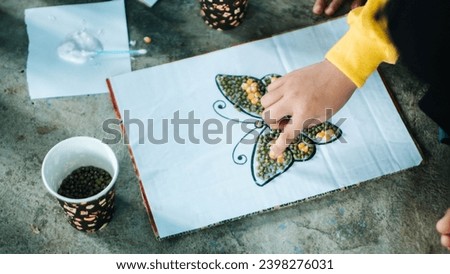 a child is coloring a picture of a butterfly using the materials around him