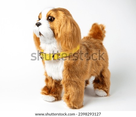 A beautiful children's toy dog of the spaniel breed on a white background.