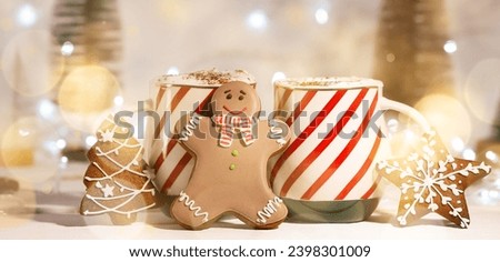 Cups of hot chocolate and gingerbread cookies on table, closeup